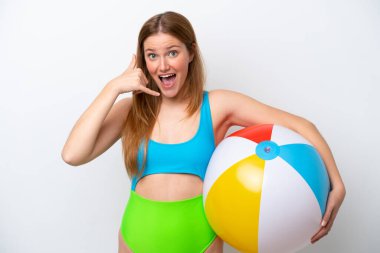 Tatillerde plaj topu tutan genç bir kadın beyaz arka planda izole edilmiş bir şekilde telefon jesti yapıyor. Bana geri dönüş işareti ver.