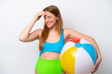 Beyaz arka planda izole edilmiş plaj topunu tutan genç kadın bir şeyin farkına vardı ve çözüme niyetlendi.