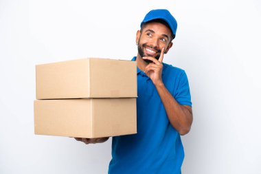 Teslimatçı Brezilyalı adam beyaz arka planda izole edilmiş, yukarı bakarken bir fikir düşünüyor.