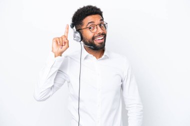 Tele pazarlamacı Brezilyalı bir adam beyaz arka planda izole edilmiş bir kulaklıkla çalışıyor. Çözümü bulmak için parmağını kaldırıyor.