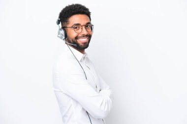 Tele pazarlamacı Brezilyalı adam kulaklıkla çalışıyor beyaz arka planda izole edilmiş, kolları bağlı ve ileriye bakıyor.