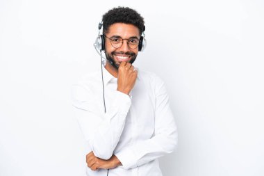 Tele pazarlamacı Brezilyalı bir adam beyaz arka planda gözlüklü ve gülümseyen bir kulaklıkla çalışıyor.