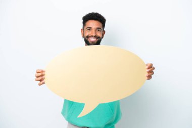 Beyaz arka planda izole edilmiş genç Brezilyalı bir adam boş bir konuşma balonu tutuyor.