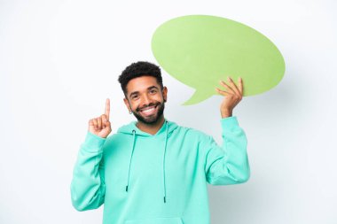Genç Brezilyalı bir adam beyaz arka planda izole edilmiş. Elinde şaşırmış bir ifadeyle boş bir konuşma balonu tutuyor.