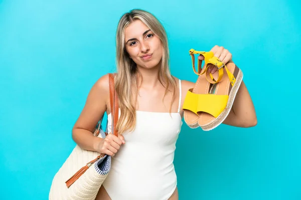 Jovem Caucasiana Segurando Sandálias Verão Isolado Fundo Azul Com Expressão — Fotografia de Stock