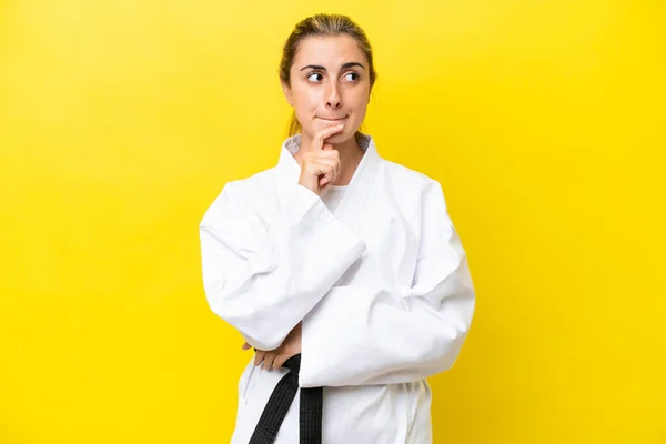 Young Caucasian Woman Doing Karate Isolated Yellow Background Having Doubts — Foto de Stock