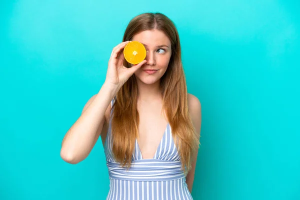 Young Woman Isolated Blue Background Swimsuit Holding Orange —  Fotos de Stock