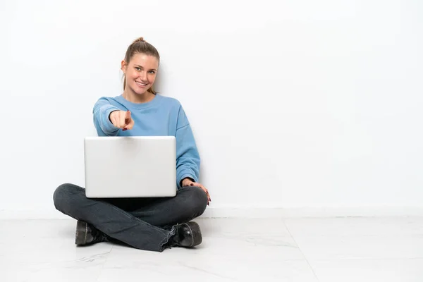 Junge Frau Mit Laptop Auf Dem Boden Zeigt Mit Selbstbewusstem — Stockfoto