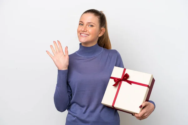 Young Caucasian Woman Holding Gift Isolated White Background Saluting Hand — 스톡 사진