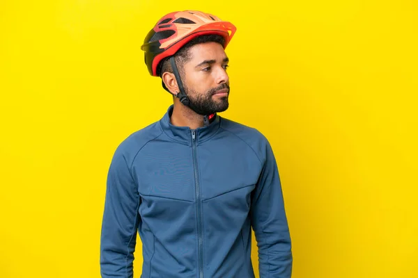 Young Cyclist Brazilian Man Isolated Yellow Background Looking Side —  Fotos de Stock
