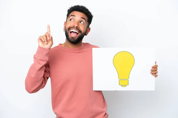 Young Brazilian Man Isolated White Background Holding Placard Bulb Icon — Foto de Stock