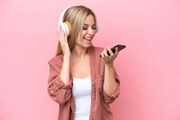 Pretty Blonde Woman Isolated Pink Background Listening Music Mobile Singing — Φωτογραφία Αρχείου
