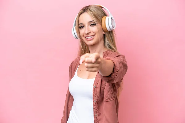 Pretty Blonde Woman Isolated Pink Background Listening Music Pointing Front — 스톡 사진