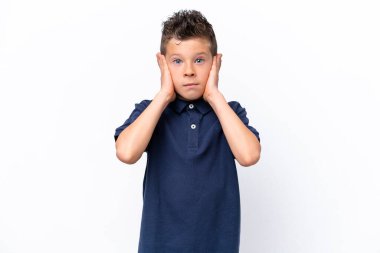 Beyaz arka planda izole edilmiş küçük beyaz çocuk hayal kırıklığına uğramış ve kulaklarını kapatmış.