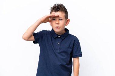 Little caucasian boy isolated on white background looking far away with hand to look something