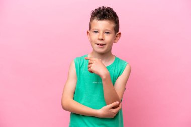 Küçük beyaz çocuk pembe arka planda izole edilmiş gülüyor.