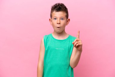 Pembe arka planda izole edilmiş küçük beyaz çocuk bir parmağını kaldırarak çözümü bulmaya çalışıyordu.