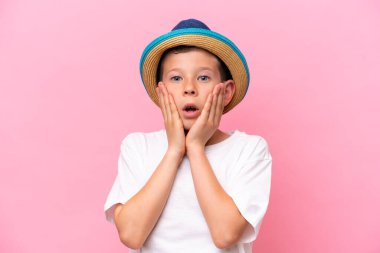 Pembe arka planda izole edilmiş şapka takan beyaz bir çocuk.