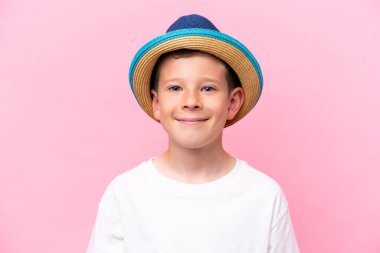 Pembe arka planda izole edilmiş şapka takan beyaz bir çocuk.