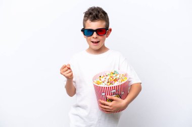 Beyaz arka planda üç boyutlu gözlüklü ve elinde koca bir kova patlamış mısır tutan beyaz tenli bir çocuk.