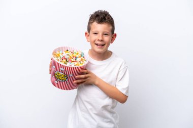 Beyaz arka planda izole edilmiş küçük beyaz çocuk elinde koca bir kova patlamış mısır tutuyor.