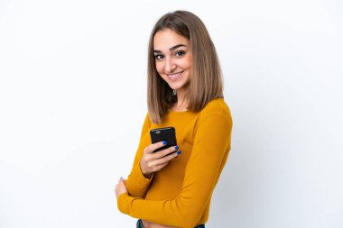 Young caucasian woman isolated on white background holding a mobile phone and with arms crossed