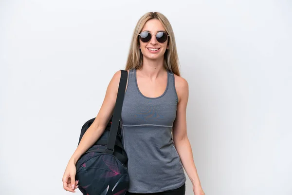 Young sport woman with sport bag isolated on white background with glasses and happy