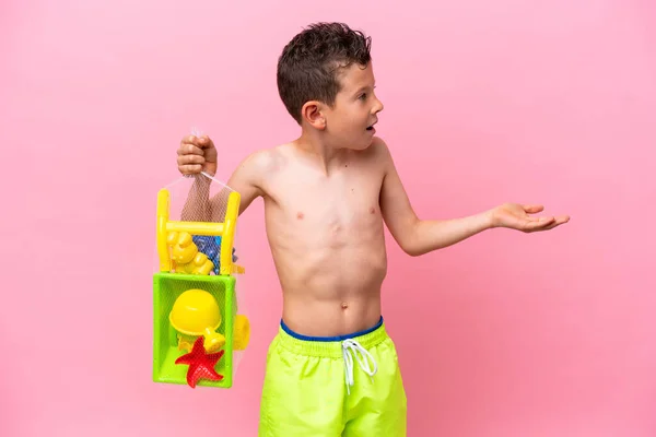 Little Caucasian Boy Holding Beach Toys Isolated Pink Background Surprise — 스톡 사진