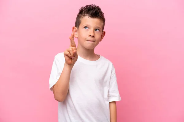 Little Caucasian Boy Isolated Pink Background Fingers Crossing Wishing Best – stockfoto