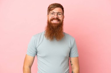 Kırmızımsı beyaz adam pembe arka planda izole edilmiş gülüyor.