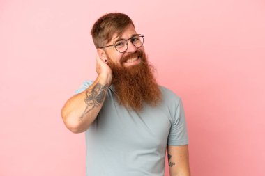 Kırmızımsı beyaz adam pembe arka planda izole edilmiş gülüyor.