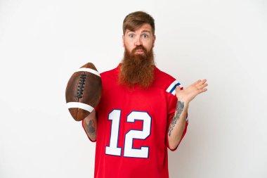 Young caucasian reddish man playing rugby isolated on white background having doubts while raising hands