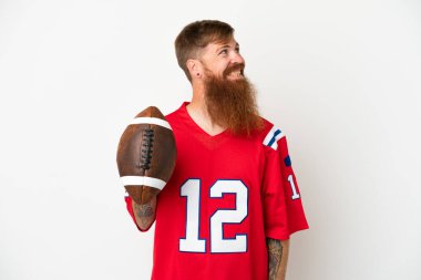 Beyaz arka planda ragbi oynayan Kafkasyalı genç bir adam bir fikir ararken kendini soyutlamış.