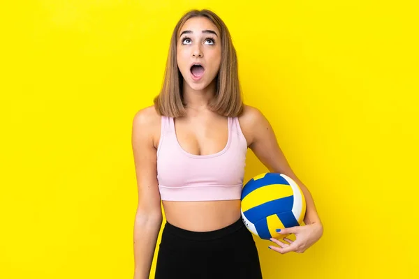 Молода Жінка Грає Волейбол Ізольовано Жовтому Тлі Дивлячись Вгору Несподіваним — стокове фото
