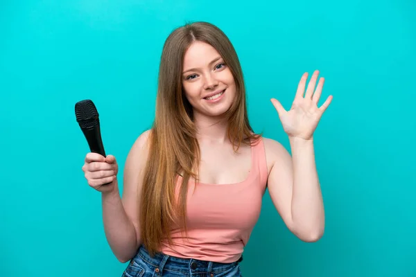 Singer Caucasian Woman Picking Microphone Isolated Blue Background Counting Five — Stockfoto