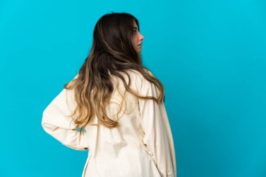 Kafkasyalı genç bir kadın mavi arka planda izole edilmiş.