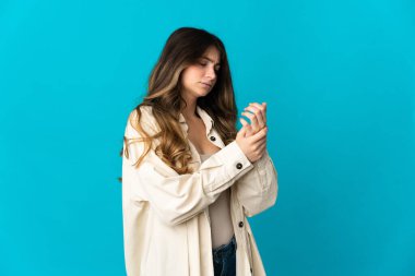 Mavi arka planda izole edilmiş beyaz bir kadın ellerinde acıdan muzdarip.