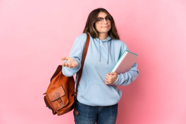 Pembe arka planda izole edilmiş genç bir bayan el kaldırırken şüphe duyuyor.