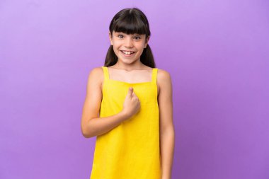 Küçük beyaz çocuk, mor arka planda yalıtılmış, şaşırmış bir yüz ifadesi var.