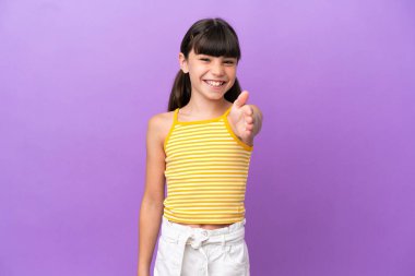 Mor arka planda izole edilmiş küçük beyaz çocuk iyi bir anlaşma için el sıkışıyor.