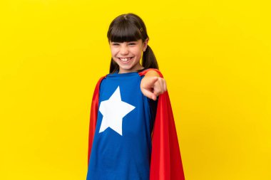 Little super hero kid isolated on purple background points finger at you with a confident expression