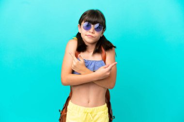 Küçük beyaz bir çocuk kumsala gidiyor. Mavi arka planda izole edilmiş. Yan taraftakilerin şüpheleri var.