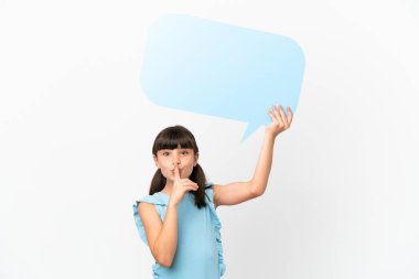 Little caucasian kid isolated on white background holding an empty speech bubble and doing silence gesture