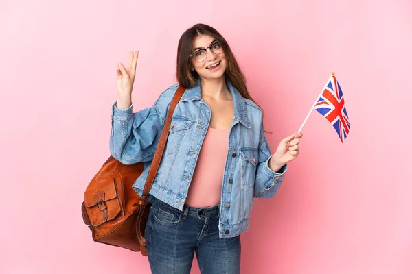 Молодая Женщина Флагом Великобритании Розовом Фоне Улыбается Показывает Знак Победы — стоковое фото