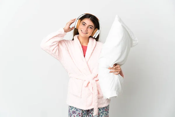 Mladý Kavkazský Žena Izolovaný Bílém Pozadí Pyžamu Drží Polštář Poslech — Stock fotografie