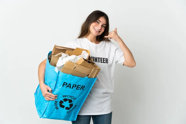 Young woman holding a recycling bag full of paper to recycle isolated on white background making phone gesture. Call me back sign