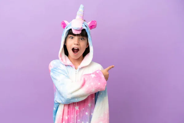 Little Kid Wearing Unicorn Pajama Isolated Purple Background Surprised Pointing — Stock Photo, Image