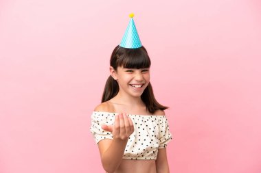 Doğum günü şapkalı küçük beyaz çocuk pembe arka planda izole edilmiş, bizimle gelmesi için davet ediliyor. Gelmene sevindim.
