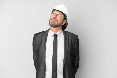 Young architect man with helmet over isolated background and looking up