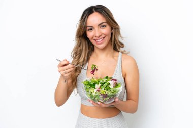 Beyaz arka planda izole edilmiş beyaz bir kadın elinde mutlu bir ifadeyle bir kase salata tutuyor.